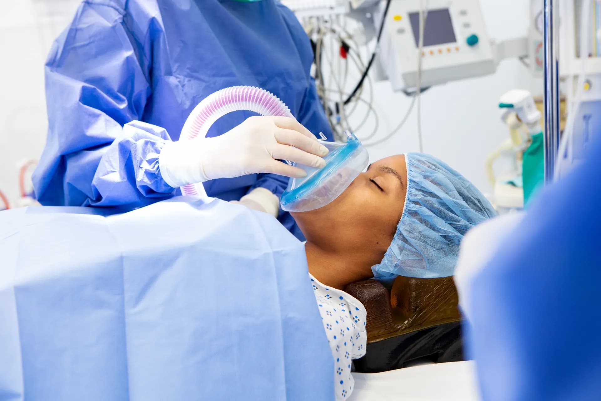 Anästhesietechnische Assistenz appliziert Beatmungsmaske bei einer Patientin